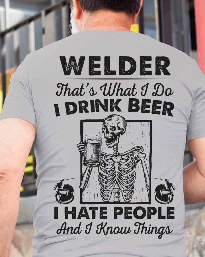 Welder-themed grey t-shirt with skeleton holding beer and quote: 'WELDER: That's What I Do. I DRINK BEER, I HATE PEOPLE, And I Know Things.' Perfect for welders with a sense of humor.