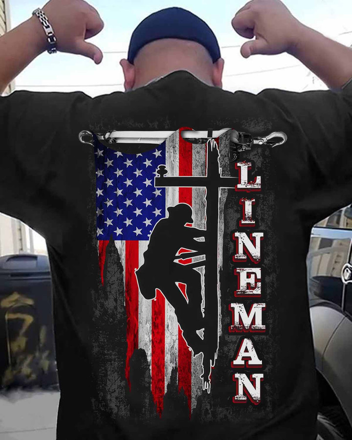 Lineman t-shirt featuring a lineman standing on an American flag, symbolizing dedication and patriotism.