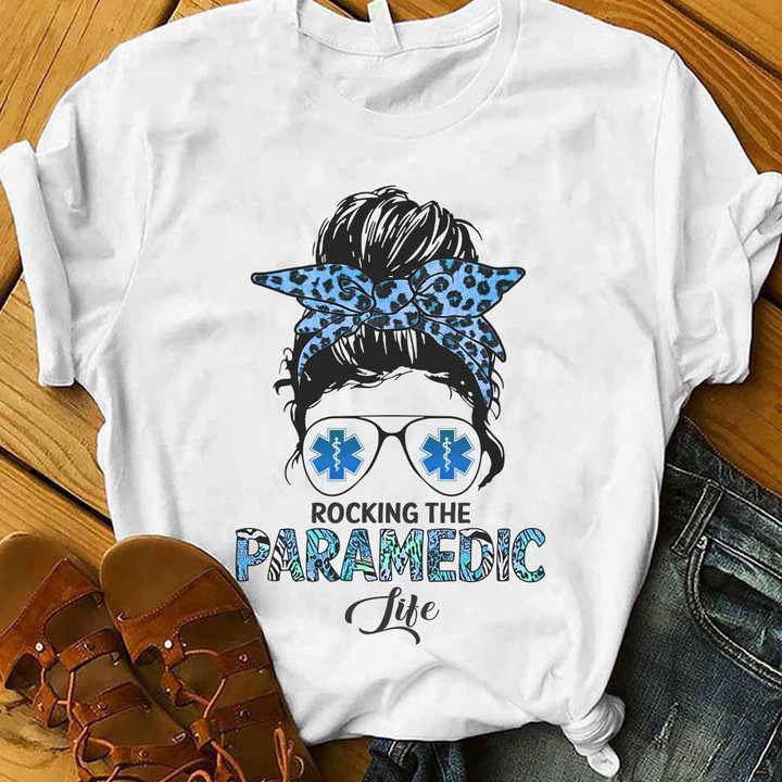 White t-shirt for paramedics with 'Rocking the Paramedic Life' quote, blue leopard print headband, and sunglasses.