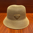 Prada Logo Plaque Straw Bucket Hat In Tan