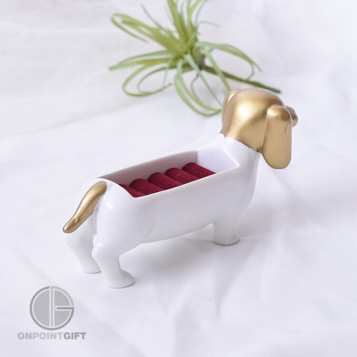 Elevate your jewelry collection with our adorable Dachshund Dog Ring Jewelry Box. This charming gold display and storage solution is perfect for keeping your rings organized and within easy reach. Not only functional, but it also adds a touch of whimsy to your home decor as a delightful ornament. Store your rings with style in this lovable Dachshund-inspired piece.