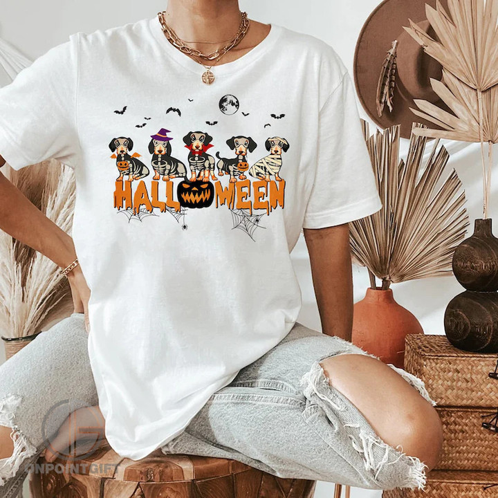 Elevate your Halloween fashion game with our Dachshund Halloween Shirt. This Y2K-inspired short sleeve tee is a must-have for Dachshund lovers and anyone looking to embrace the festive spirit of the fall season. Featuring an adorable Dachshund and pumpkin design, it's the perfect balance of spooky and cute. The shirt is not only a tribute to your furry friend but also a nod to the trendy Y2K style, making it a versatile addition to your wardrobe. Crafted with quality and comfort in mind, this shirt ensures a cozy fit and a unique streetwear and harajuku vibe. Whether you're going out for a Halloween party or just want to showcase your love for these lovable dogs, this Dachshund Halloween Shirt is a standout choice for your fall fashion.