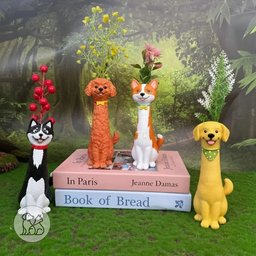 A collection of handcrafted, cartoon-style elongated resin dog vases shaped like a Golden Retriever, Poodle, Husky, and Corgi holding decorative plants on a desk.