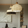 This picture shows two white and wood rattan woven vintage pendant lamp in the dining room. 
