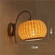 This picture shows a woven bamboo wall light in size 20cm 