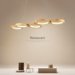 This picture shows a modern LED wooden linear circle pendant lamp in the dining room.
