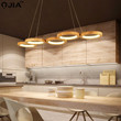 This picture shows a modern LED wooden linear circle pendant lamp in the kitchen.