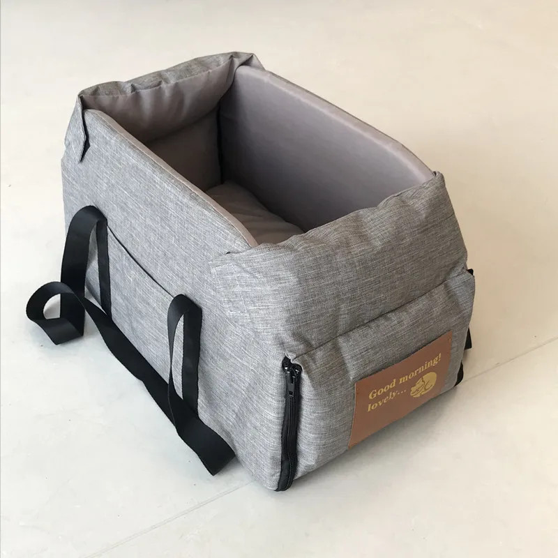 Chihuahua sitting in grey console dog car seat on centre armrest — small breed car booster