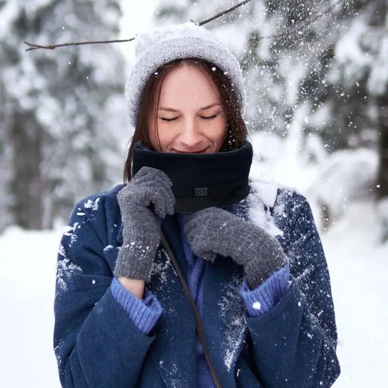 A woman outdoors in the snow wearing the Heated Neck Warmer Scarf