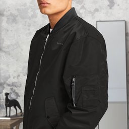 Black QADIM bomber jacket side view with sleeve pocket