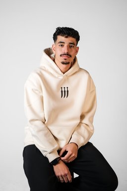 Jambiya hoodie in beige worn by a model – jambiya dagger with Arabic calligraphy print by QADIM