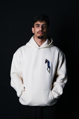Safar hoodie in beige worn by a model – black horse with blue florals and cowboy hat print by QADIM
