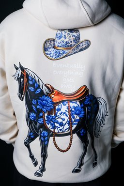 Close-up of the Safar hoodie print – black horse with blue florals and cowboy hat