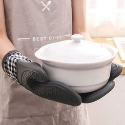 Heat resistant silicone gloves holding white hot casserole dish - anti-slip kitchen protection