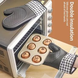 Person using thickened silicone oven mitts to pull hot muffin tray from oven - double insulation