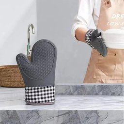 Grey silicone oven glove with checkered pattern hanging in modern kitchen near sink