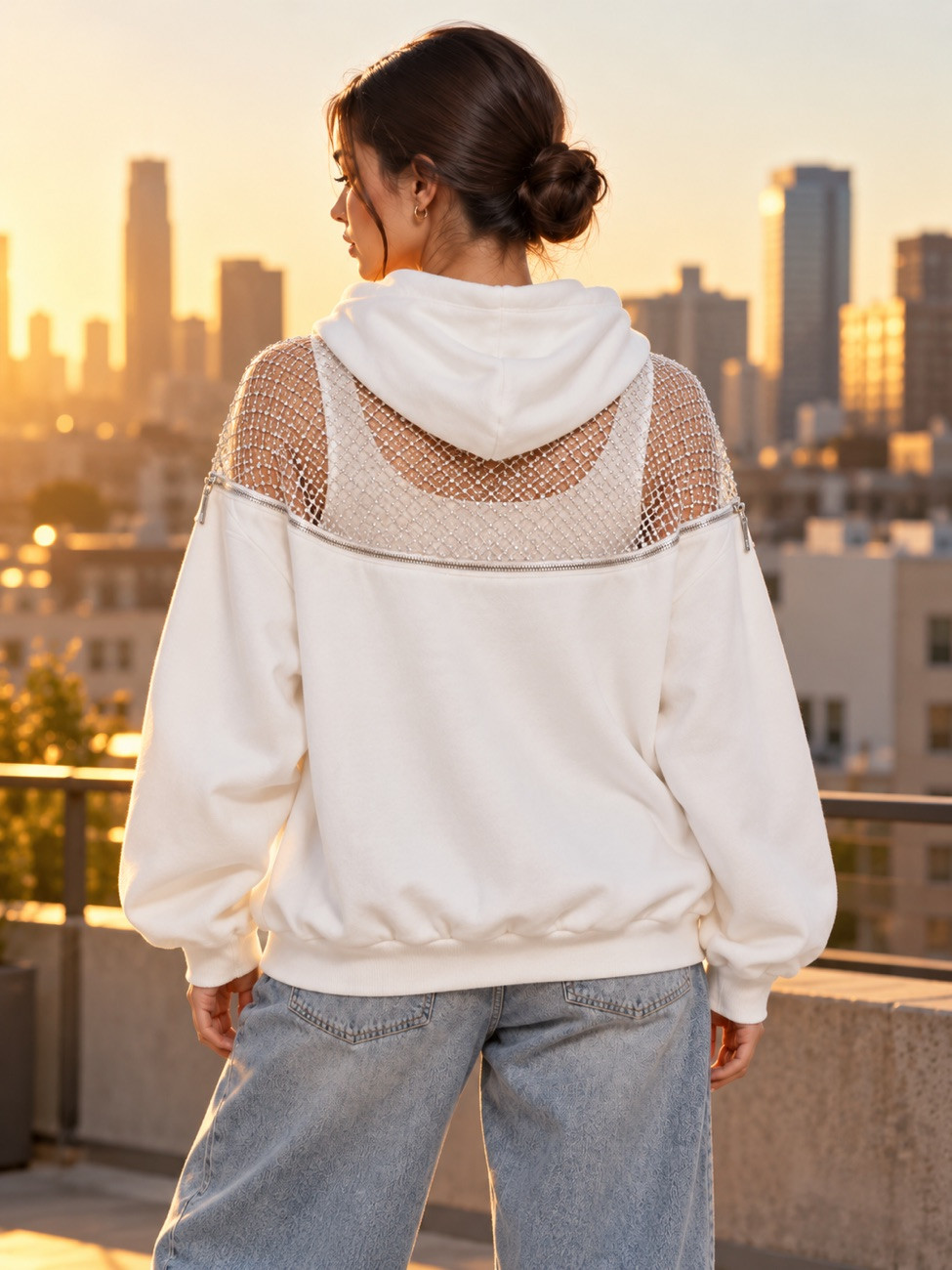 Woman from behind in the white hoodie in bright daylight, the zip and mesh yoke visible