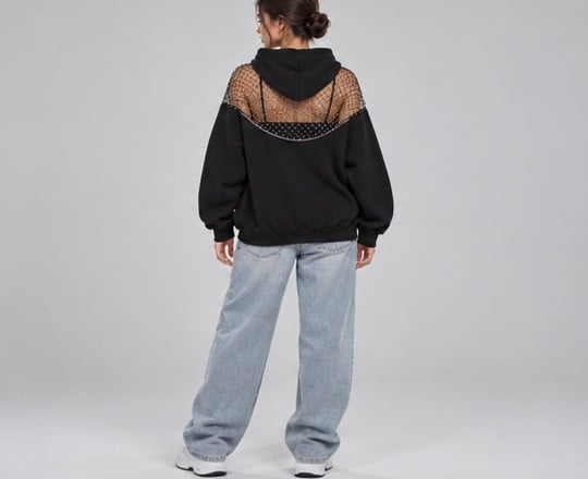 Model from behind in the black hoodie; the rhinestone mesh yoke shows across her upper back