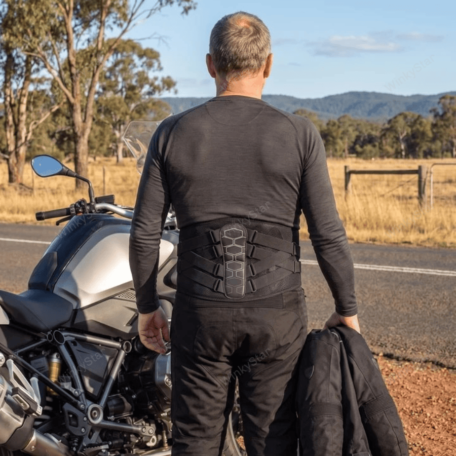 Rider beside the motorcycle wearing MotoSupport, seen from behind