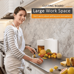 Woman using large stainless steel chopping board for food preparation in kitchen