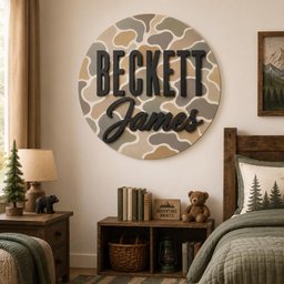 May include: A circular wall sign featuring a camouflage pattern in shades of tan, olive green, and grey. The name Beckett is displayed in large, black, sans-serif capital letters, with the name James in a black, cursive script font below it.