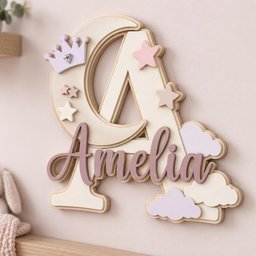 May include: A large wooden letter A in a light cream color, featuring a crescent moon cutout, a light purple crown with a clear gem, and several stars in pink and beige. The name Amelia is written in cursive dark mauve script over the letter.
