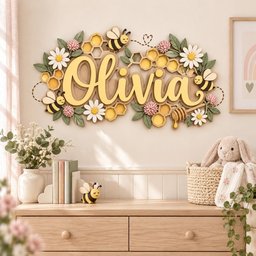 May include: A wall-mounted wooden sign featuring the name Olivia in yellow script lettering, surrounded by decorative honeycomb patterns, white daisy flowers, pink clover blossoms, green leaves, and cartoon bees with a honey dipper.