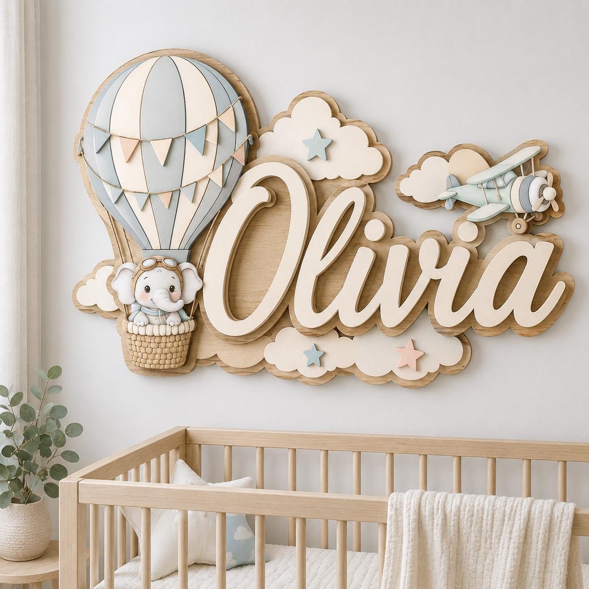 May include: A wooden wall sign featuring the name Olivia in large white script letters. The design includes a light blue and white hot air balloon with a small elephant in the basket, white clouds, small stars, and a light blue biplane airplane.