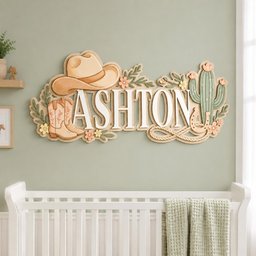 May include: A decorative wooden wall sign featuring the name ASHTON in large white letters. The design includes a tan cowboy hat, a pair of tan cowboy boots, a green cactus, a horseshoe, a coiled rope, and small pastel-colored flowers and leaves.
