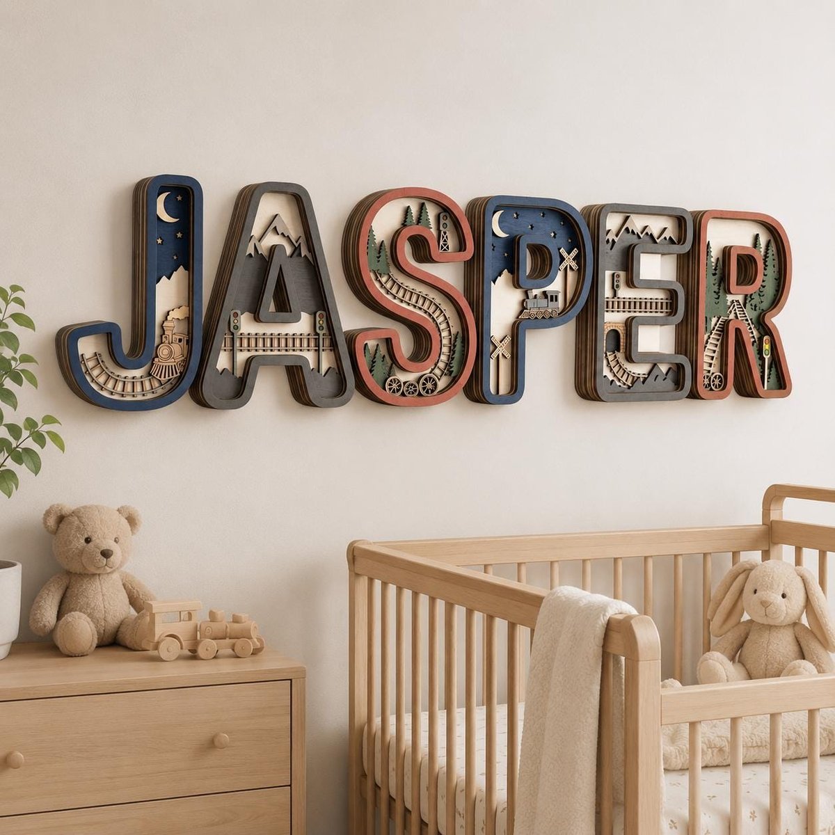 May include: A multi-layered wooden wall sign spelling the name JASPER, featuring intricate cutouts of trains, tracks, mountains, and trees within each letter. The design uses a color palette of navy blue, dark gray, cream, and terracotta accents.