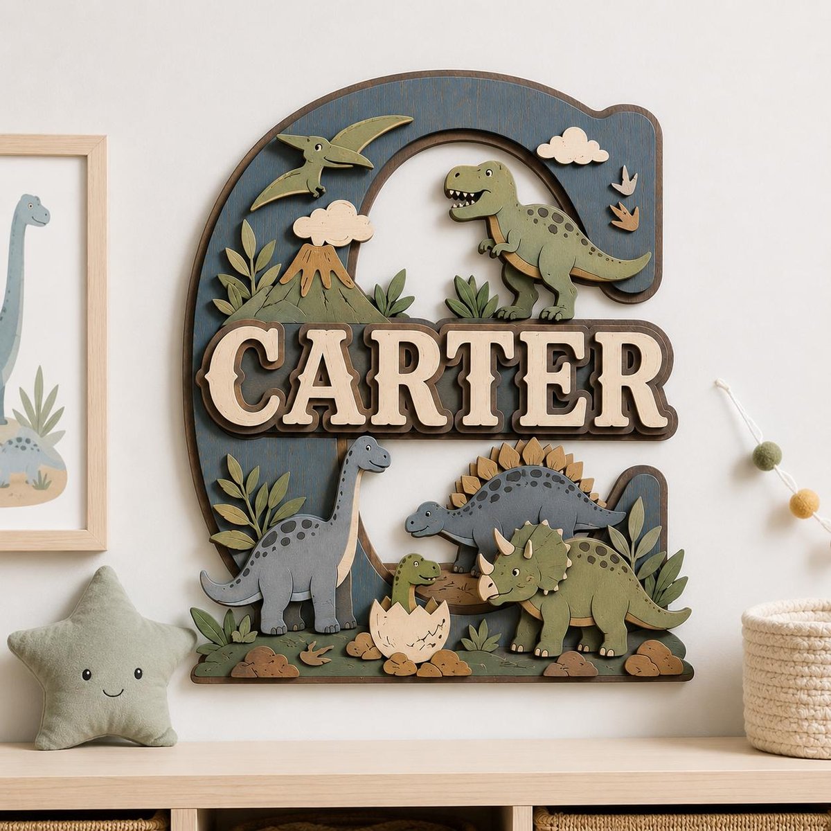 May include: A large, layered wooden letter E wall decoration featuring a dinosaur theme with the name CARTER in raised lettering. The design includes a green T-Rex, a blue long-necked dinosaur, a triceratops, a baby dinosaur in an egg, and a volcano.