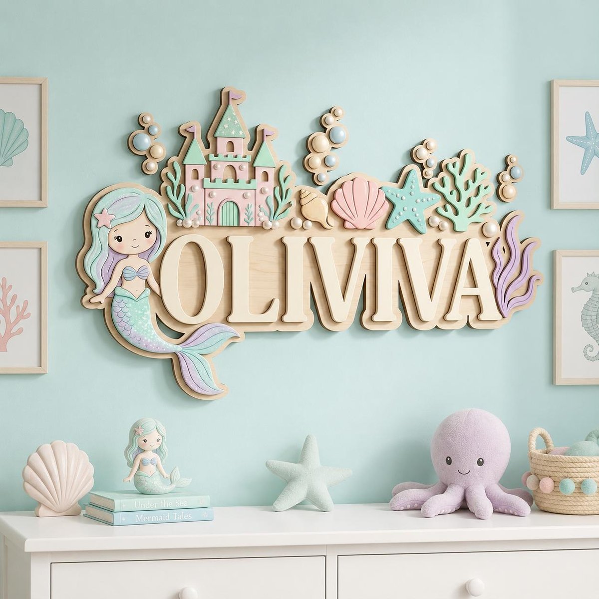 May include: A wall-mounted wooden sign featuring the name OLIVIA in large capital letters, decorated with a pastel-colored mermaid, a castle, seashells, a starfish, and coral. The design uses shades of pink, mint green, and lavender.