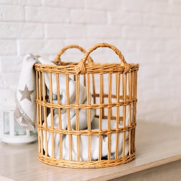This picture shows a scene which a rattan laundry basket in the bathroom.